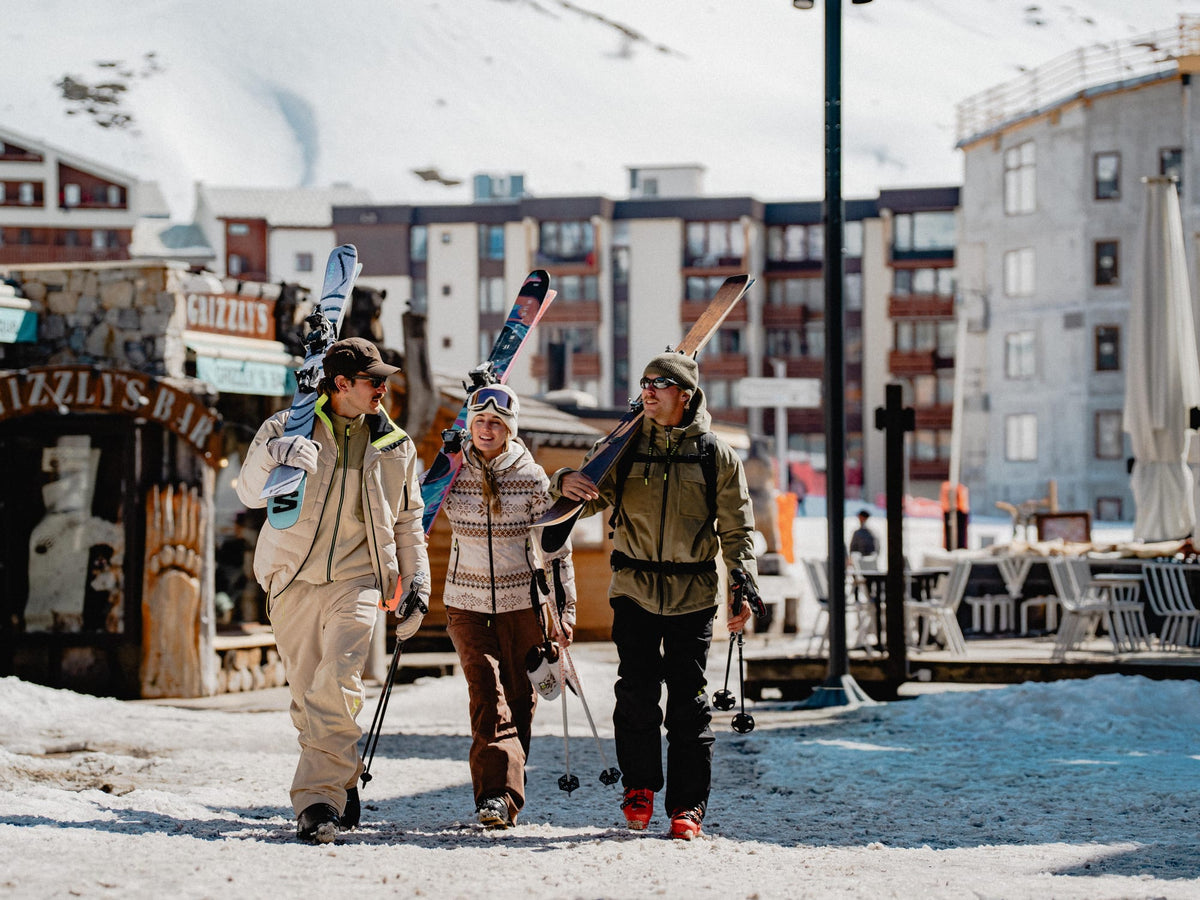 Groupe d amis en polaires Sun Valley, skis sur l epaule, dans la station